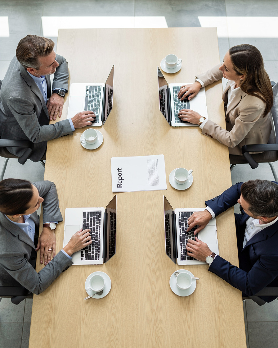 Overhead view of professionals working around a conference table