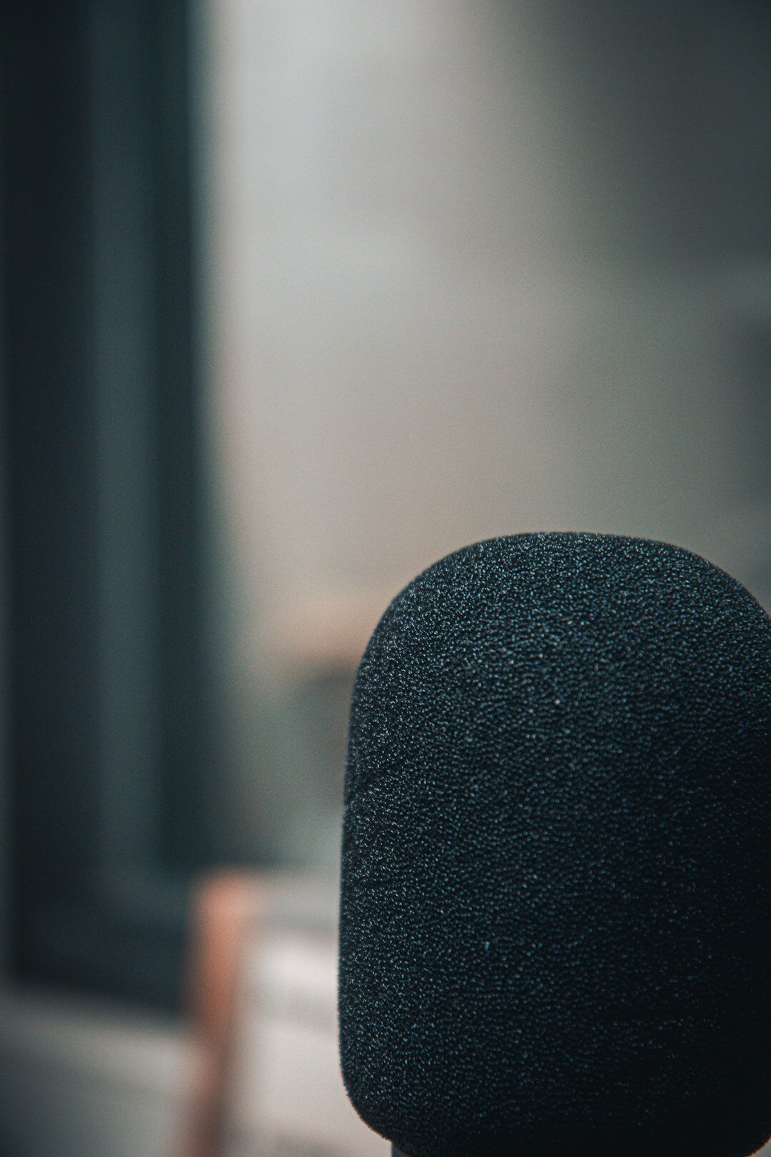 Close-up of a studio microphone and notes on a wooden table