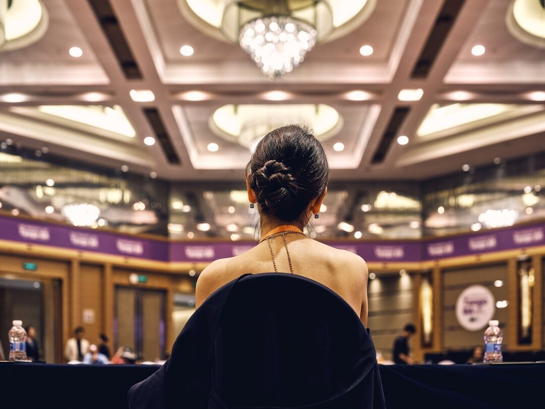 Speaker presenting to a panel and audience in a conference hall